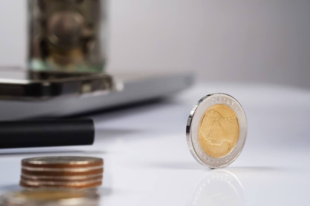 a gold and silver coin sitting up on its edge on a desk