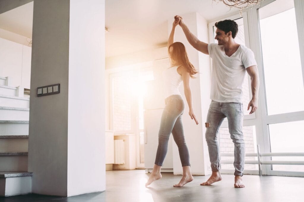 Happy couple dancing after purchasing non-warrantable condo