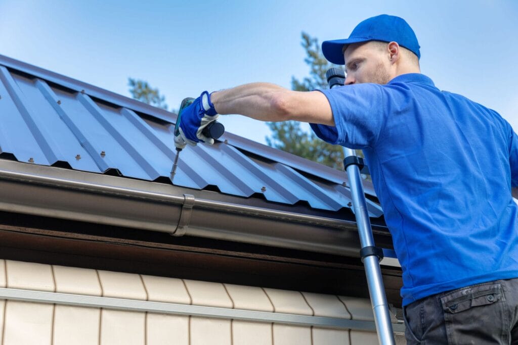 metal roofing - roofer working on the house roof