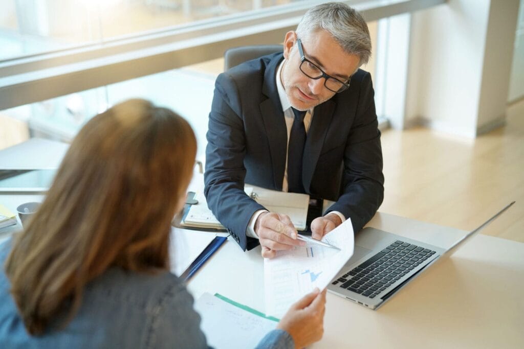 Woman in banker's office signing financial loan for project