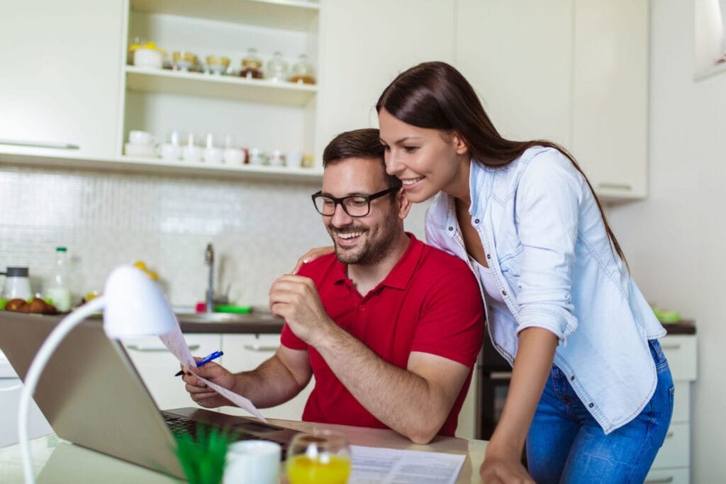 Young couple managing finances, reviewing their bank accounts with bank statements