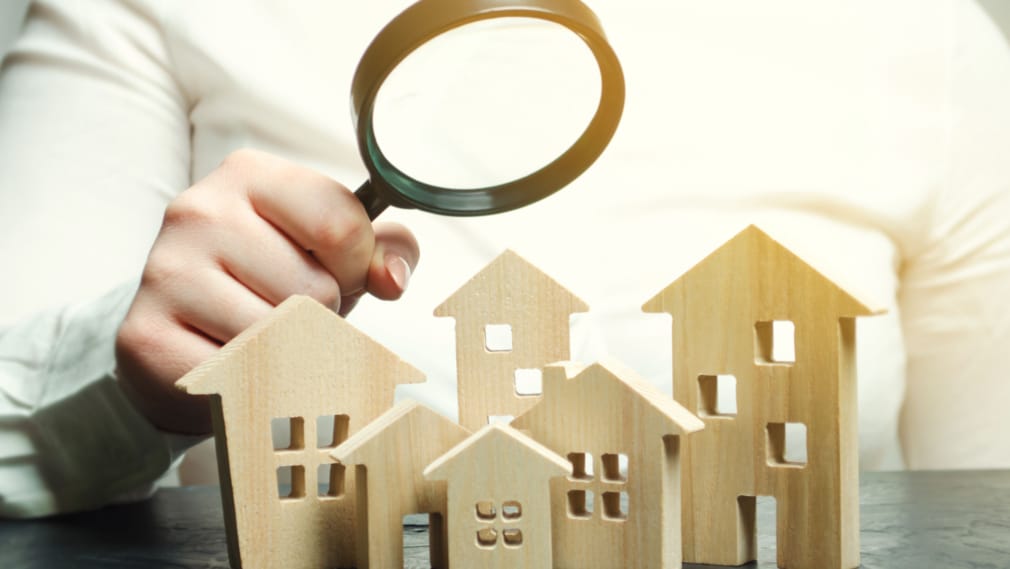 Magnifying glass over wooden homes